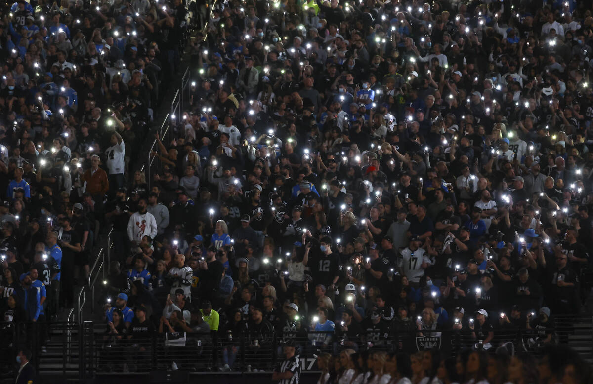 Raiders fans light their phones in memory of John Madden during the first half of an NFL footba ...