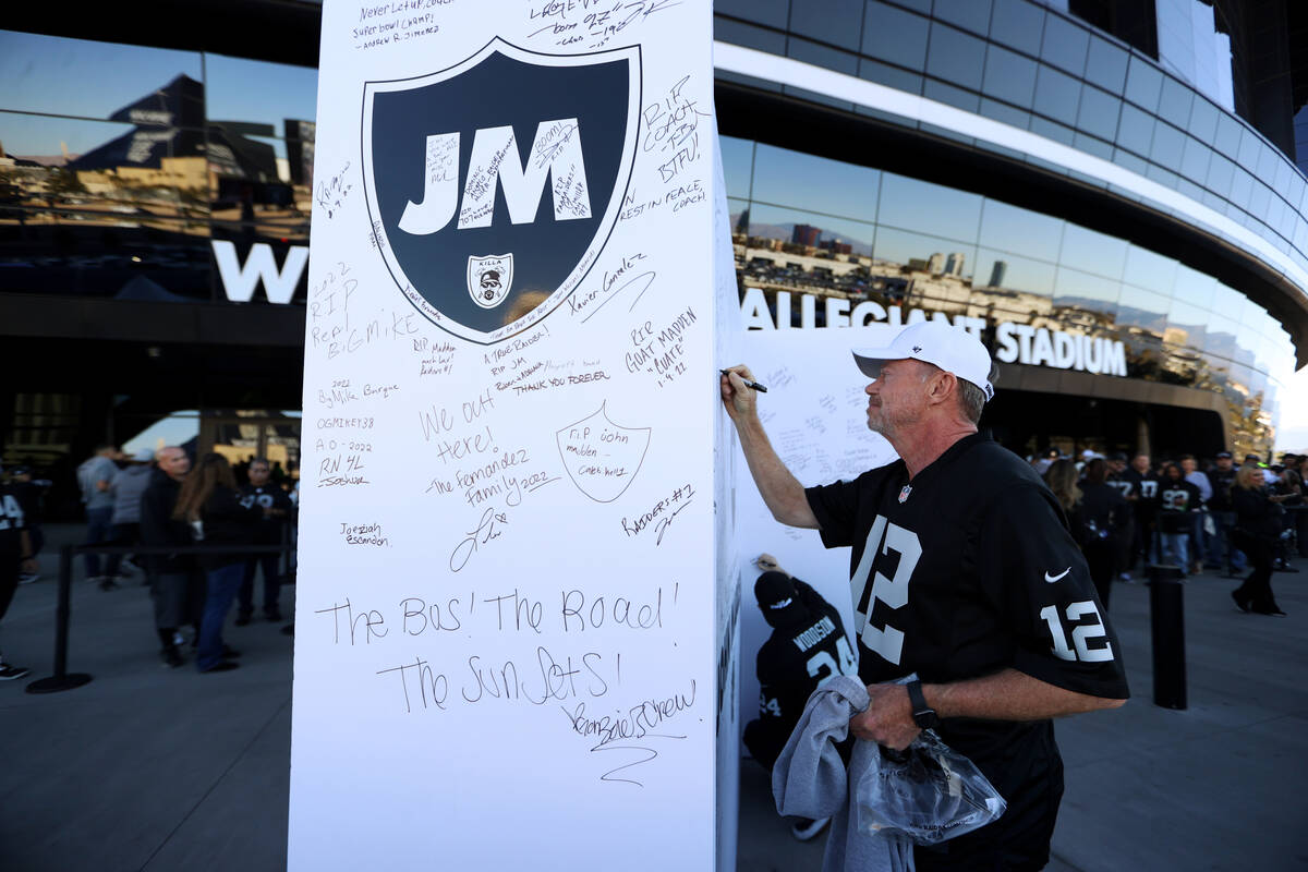 Tim Flowers signs a John Madden tribute wall before the start of an NFL football game between t ...