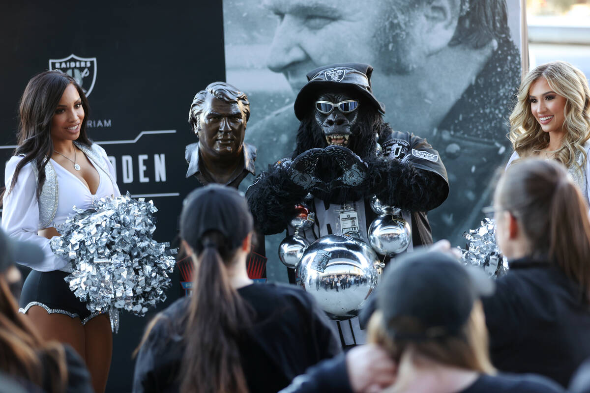 Raiders fan Gorilla Rilla takes a photo with a John Madden statue before the start of an NFL fo ...