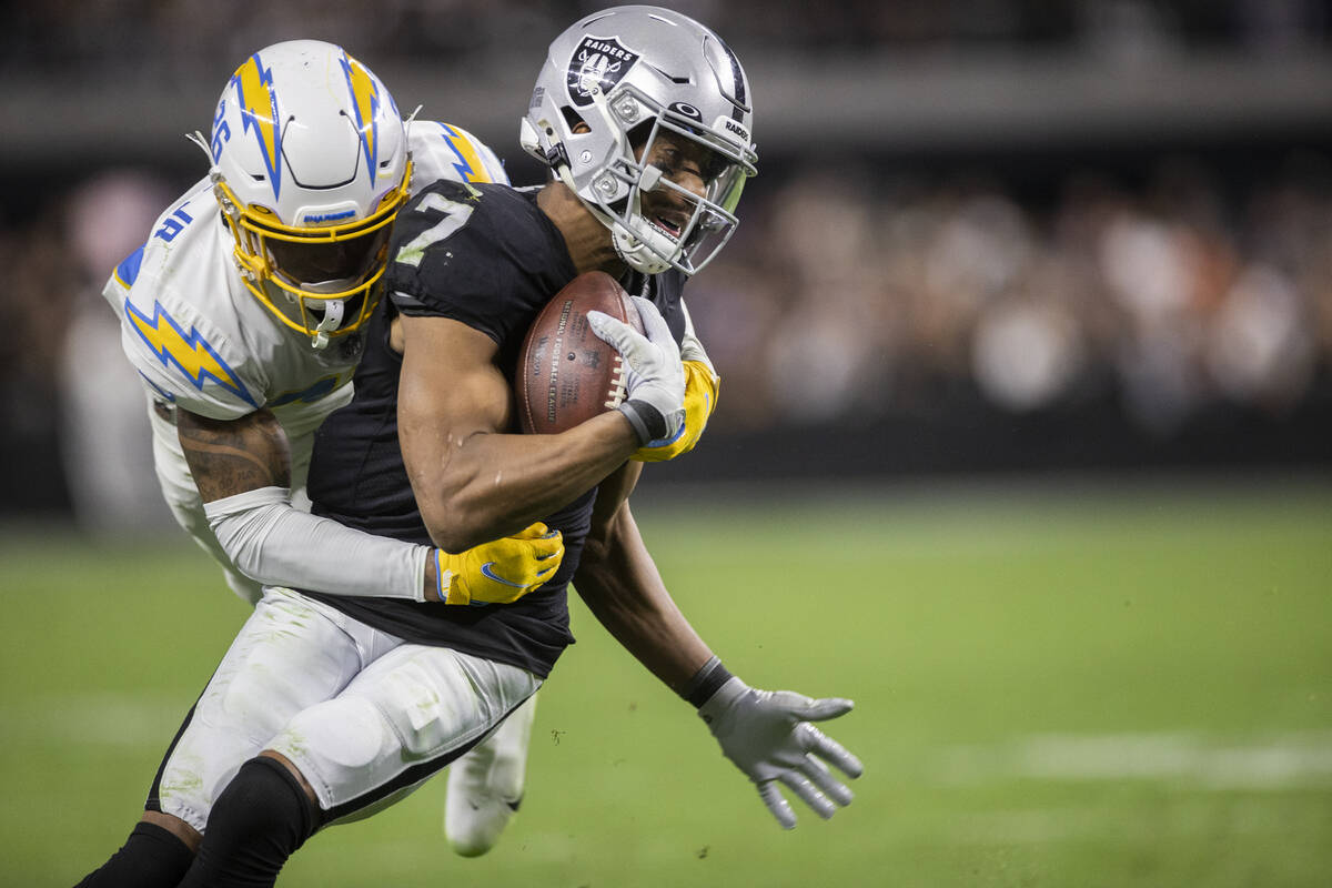 Raiders wide receiver Zay Jones (7) fights for yardage with Los Angeles Chargers cornerback Asa ...