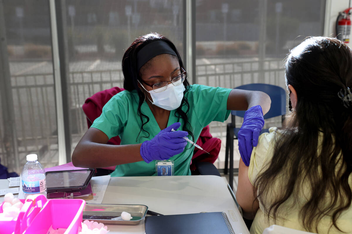 Adwoa Fosu gives a shot to Olivia Ramirez of Las Vegas at a COVID-19 vaccination station at Sou ...