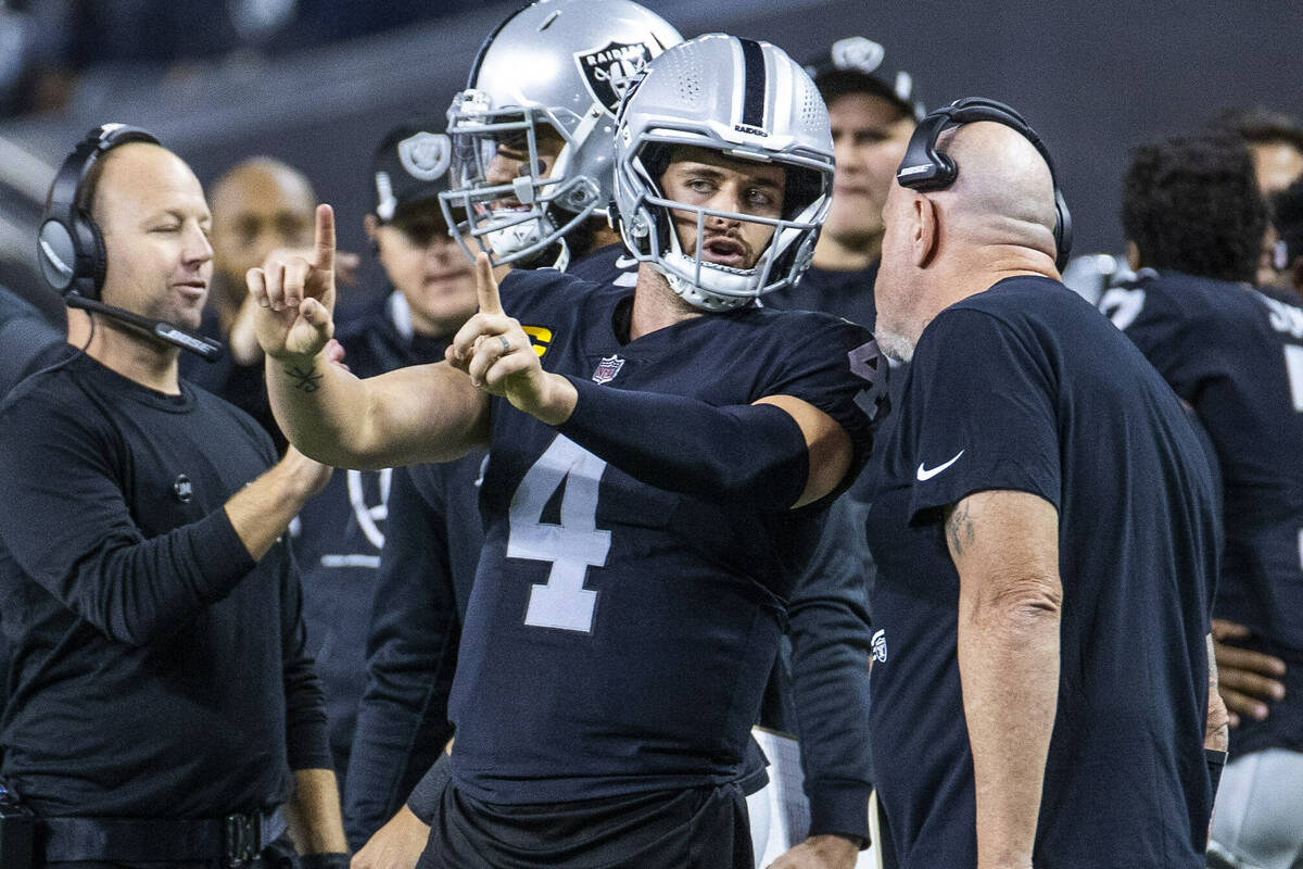 Raiders quarterback Derek Carr (4) talks with a coach on the sidelines versus the Los Angeles C ...