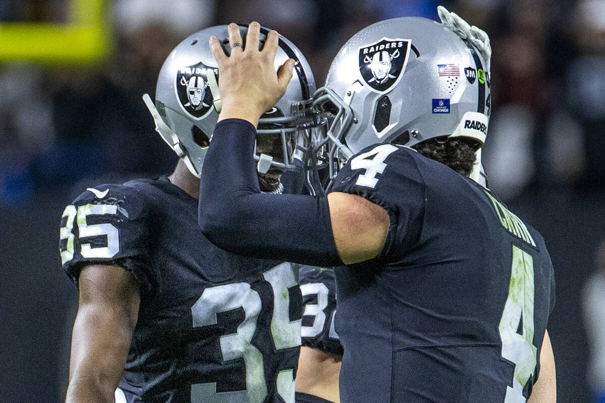 Raiders cornerback Brandon Facyson (35) comes together with Raiders quarterback Derek Carr (4) ...