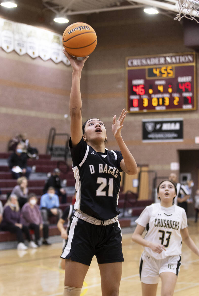 Desert Oasis’ Lata Fakahafua (21) shoots over Faith Lutheran’s Emma Herpin (33) i ...