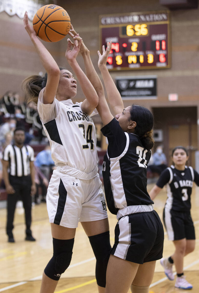 Faith Lutheran’s Leah Mitchell (34) shoots over Desert Oasis’ Lata Fakahafua (21) ...