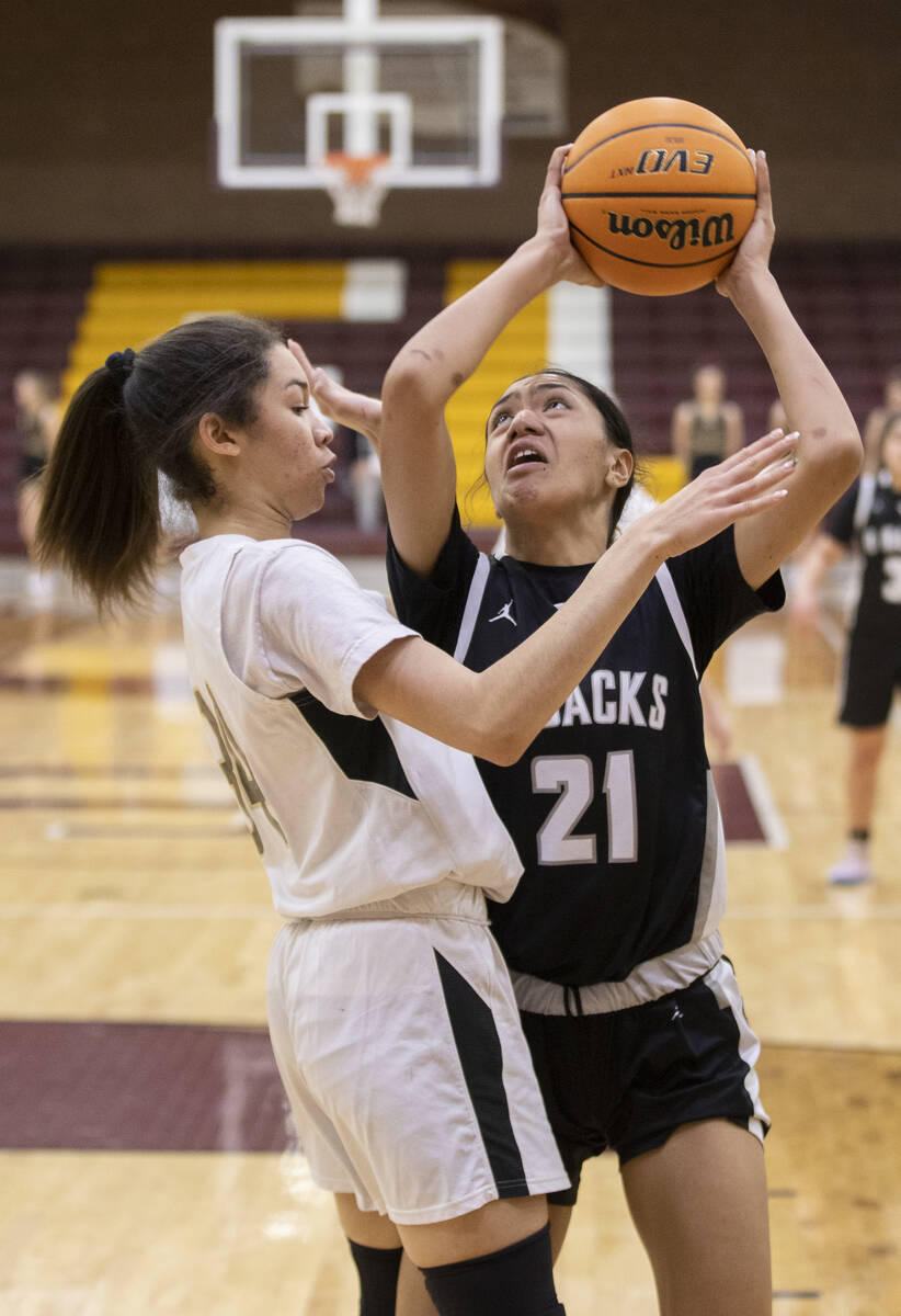 Desert Oasis’ Lata Fakahafua (21) shoots over Faith Lutheran’s Leah Mitchell (34) ...