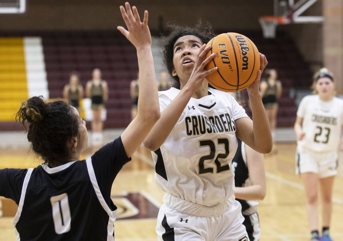 Faith Lutheran’s Ariel Thomas (22) drives past Desert Oasis’ Olivia Bigger (0) in ...