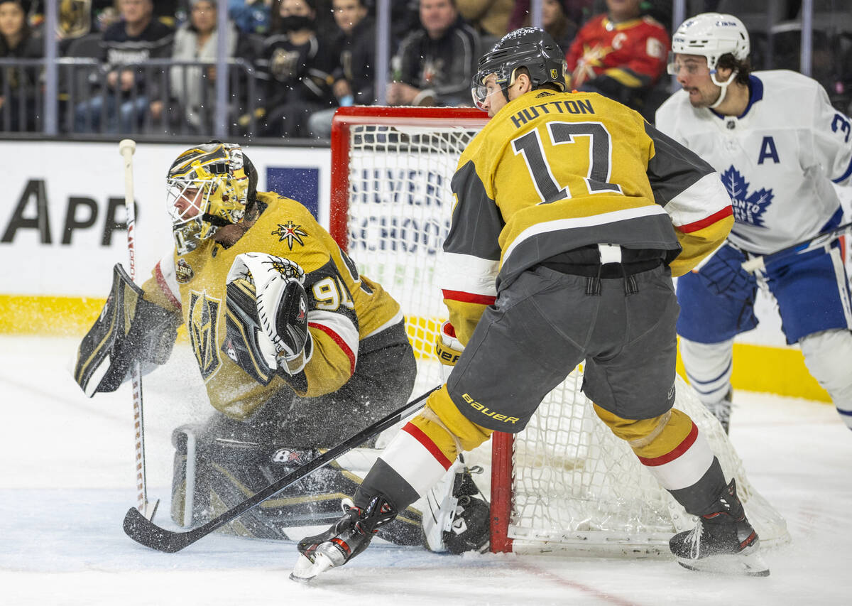 Golden Knights goaltender Robin Lehner (90) looks to make a stop with Golden Knights defenseman ...