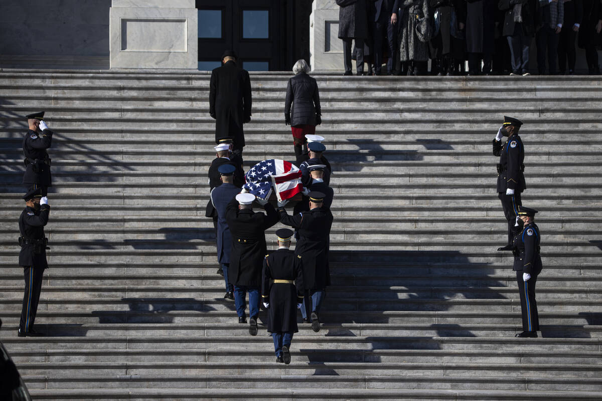 A military honor guard carries the flag-draped casket of former Sen. Harry Reid up the steps of ...