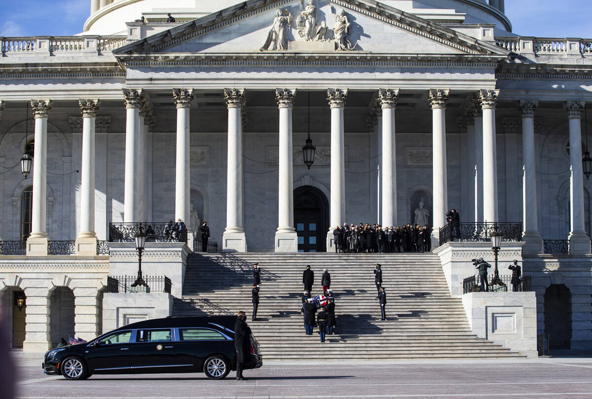 A military honor guard carries the flag-draped casket of former Sen. Harry Reid up the steps of ...