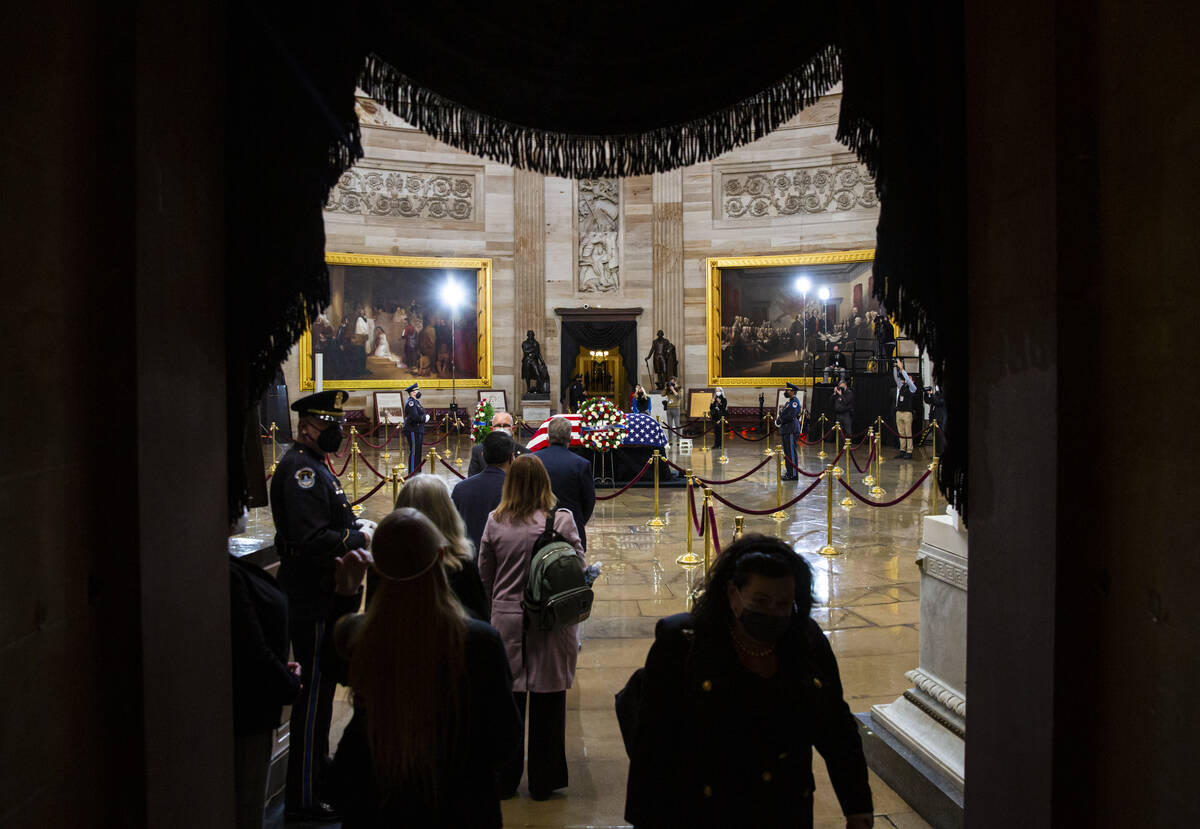 People line up to pay their respects while viewing the flag-draped casket of former Sen. Harry ...