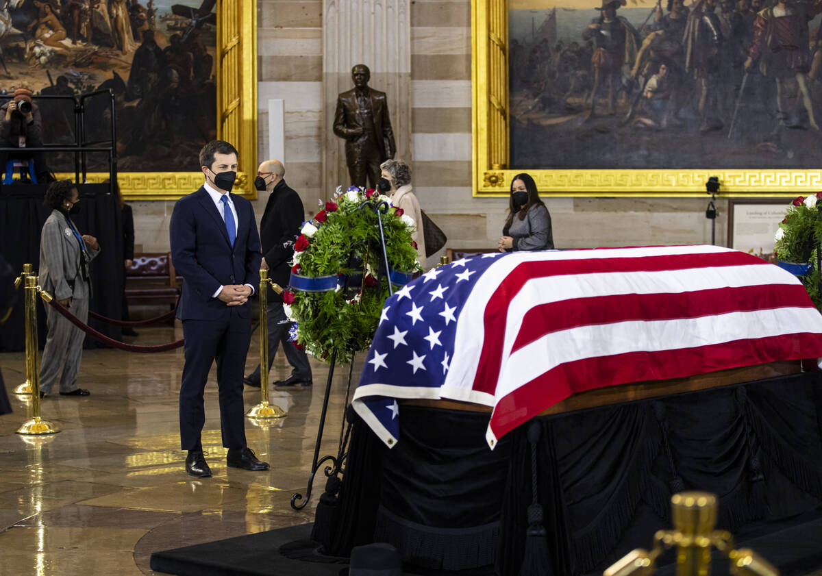 Pete Buttigieg, Secretary of Transportation, pays respects while viewing the flag-draped casket ...