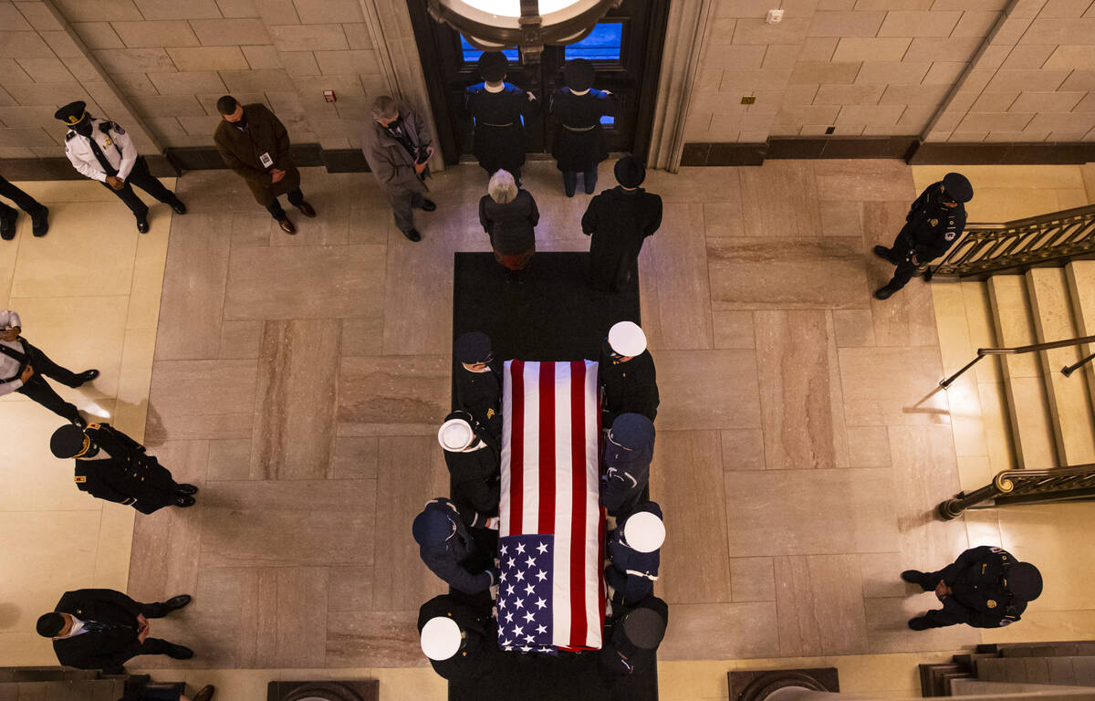 A military honor guard carries the flag-draped casket of former Sen. Harry Reid for departure a ...