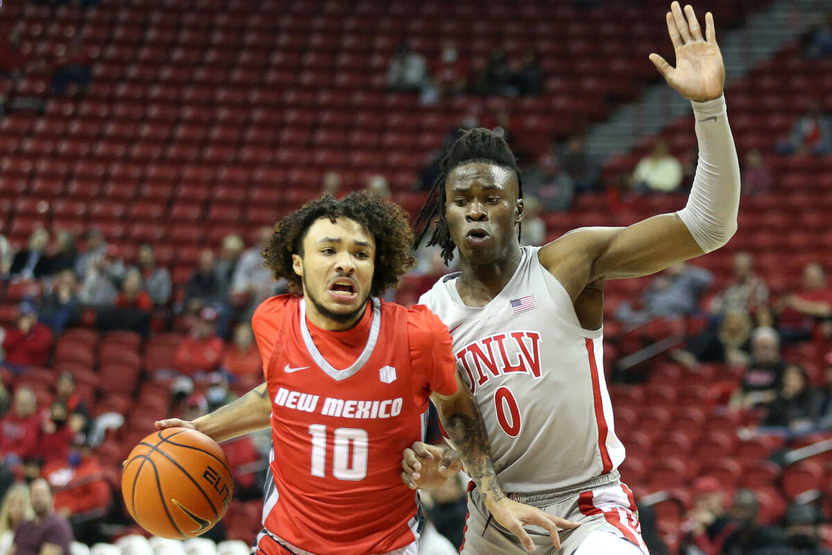 New Mexico Lobos guard Jaelen House (10) drives around UNLV Rebels forward Victor Iwuakor (0) d ...