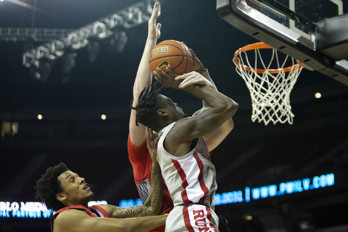 UNLV Rebels guard Michael Nuga (1) shoots against New Mexico Lobos guard Taryn Todd, left, and ...