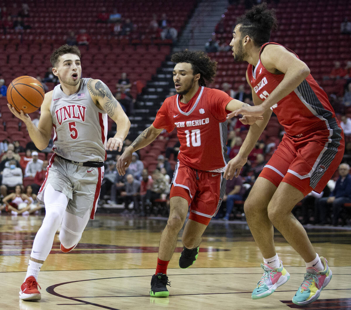 UNLV Rebels guard Jordan McCabe (5) drives around New Mexico Lobos guard Jaelen House (10) and ...