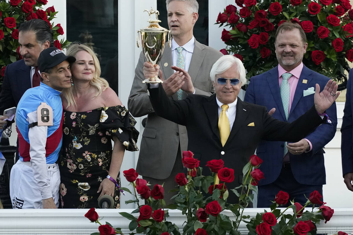 Jockey John Velazquez, left, watches as trainer Bob Baffert holds up the winner's trophy after ...