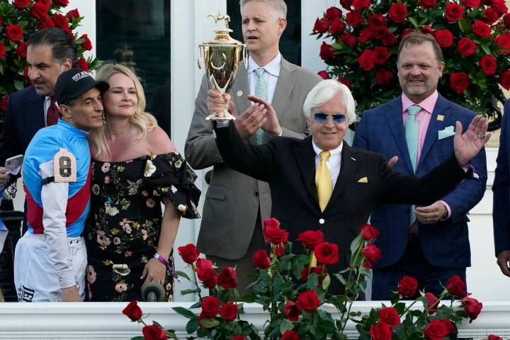 Jockey John Velazquez, left, watches as trainer Bob Baffert holds up the winner's trophy after ...