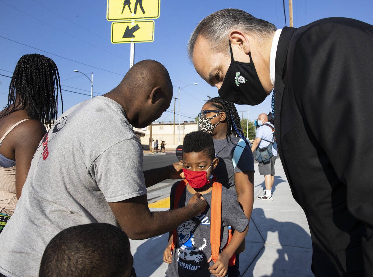 Cladde Lea left, adjusts his son IsaiahÕs, 6, face mask as Superintendent Dr. Jesus Jara t ...