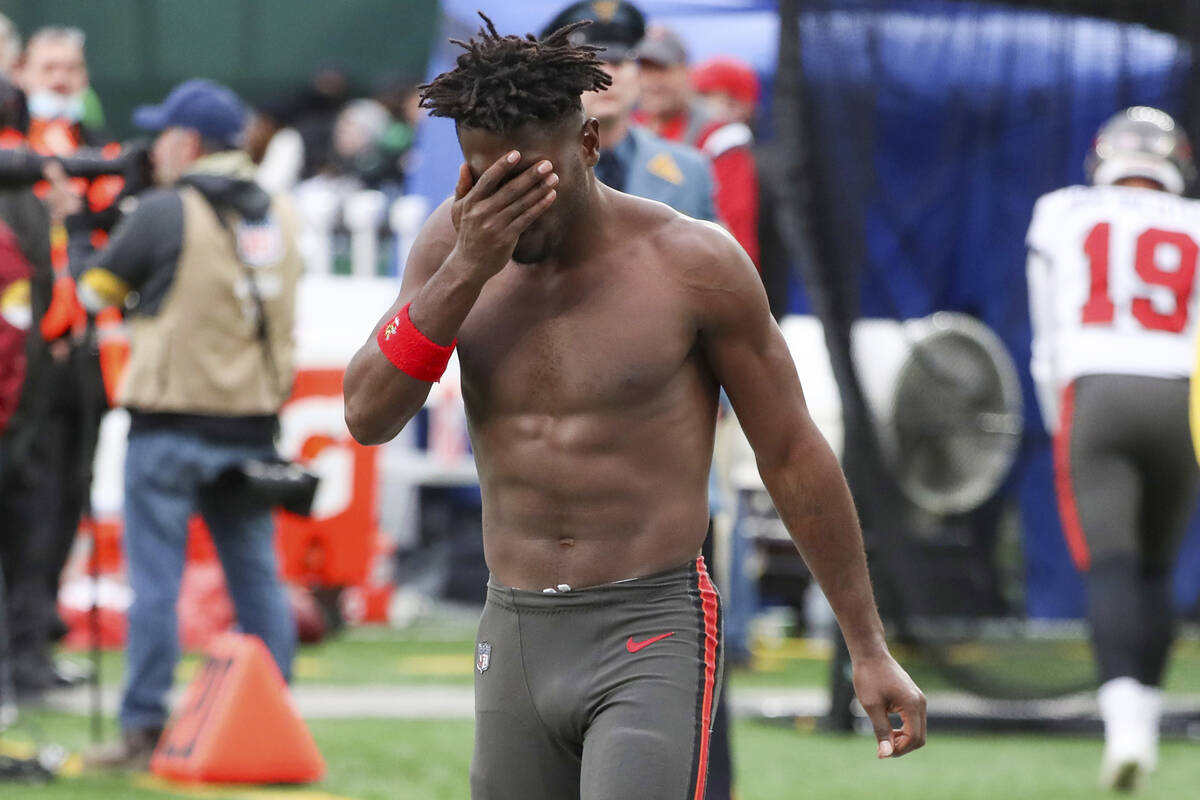 Tampa Bay Buccaneers wide receiver Antonio Brown wipes his face as he leaves the field after th ...