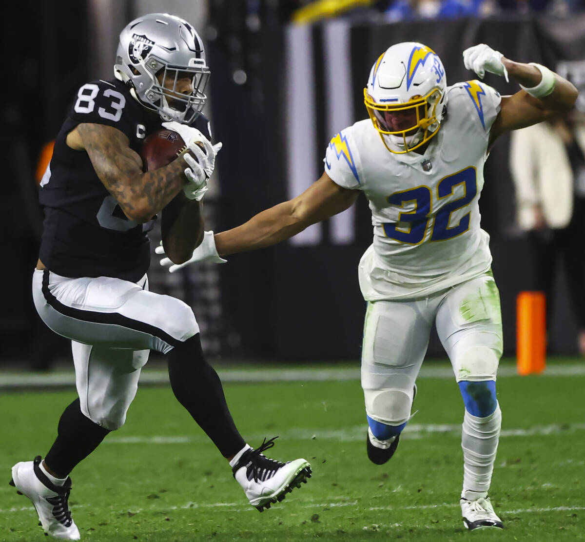 Raiders tight end Darren Waller (83) runs the ball as Los Angeles Chargers safety Alohi Gilman ...