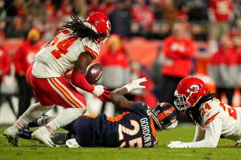 Denver Broncos running back Melvin Gordon III (25) loses a fumble after being hit by Kansas Cit ...