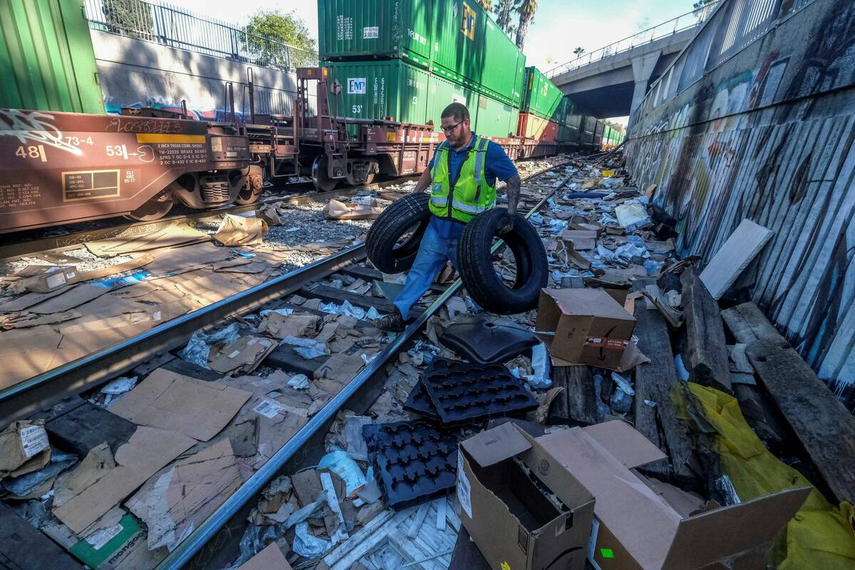 Contractor worker Adam Rodriguez picks up vehicle tires from the shredded boxes and packages al ...