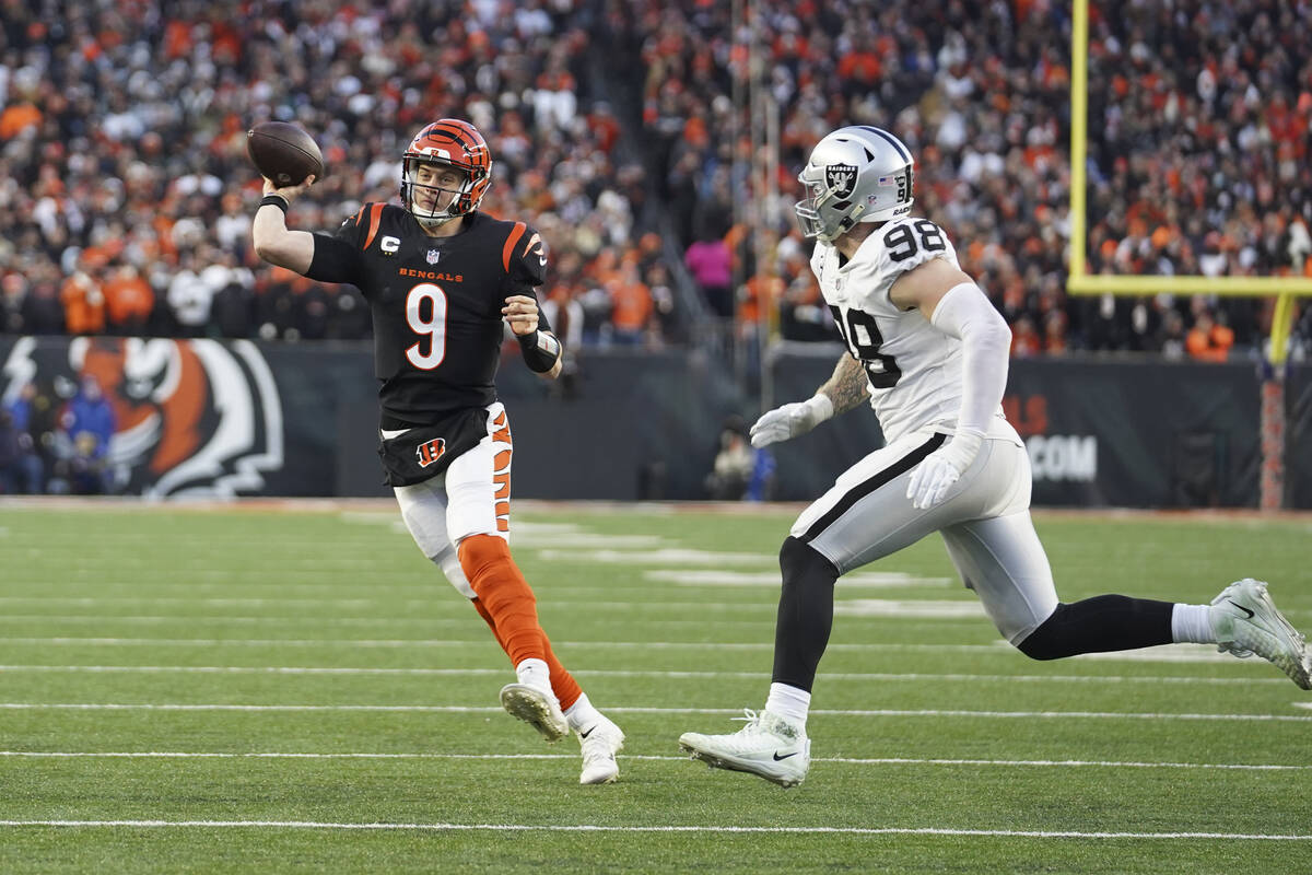 Cincinnati Bengals quarterback Joe Burrow (9) throws while being pressured by Las Vegas Raiders ...