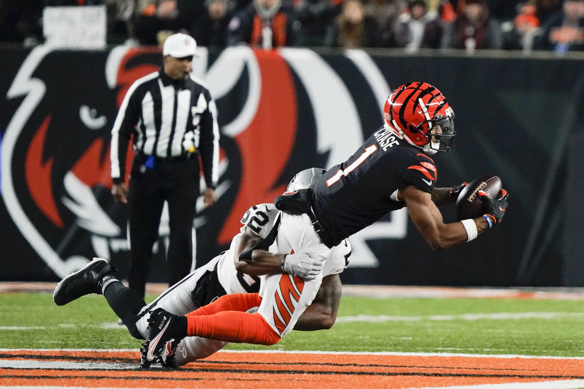 Cincinnati Bengals' Ja'Marr Chase (1) makes a catch against Las Vegas Raiders' Denzel Perryman ...