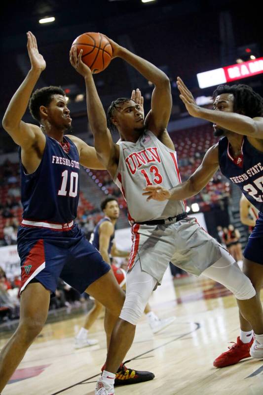 UNLV Rebels guard Bryce Hamilton (13) keeps a ball away from Fresno State Bulldogs forward Orla ...