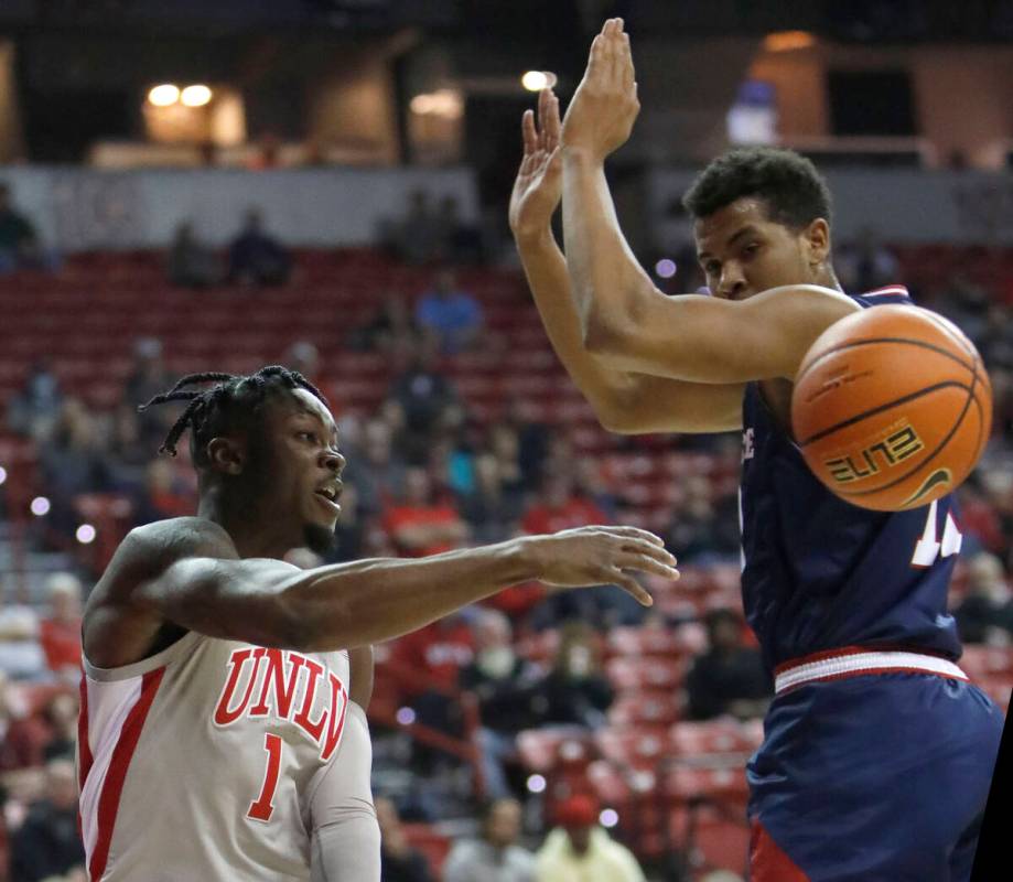 UNLV Rebels guard Michael Nuga (1) passes a ball as Fresno State Bulldogs forward Orlando Robin ...