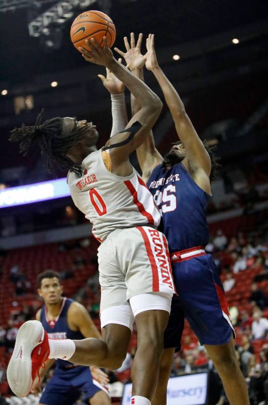 UNLV Rebels forward Victor Iwuakor (0) tries to shoot over Fresno State Bulldogs guard Anthony ...
