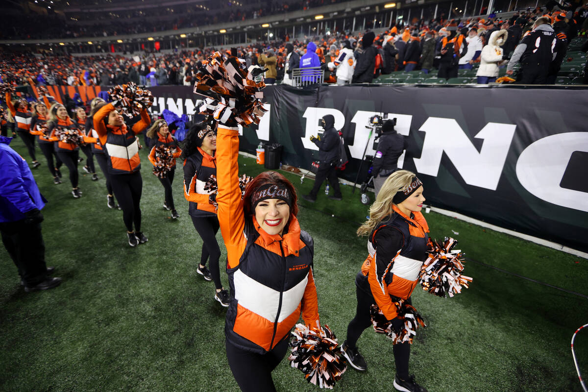 Cheerleaders walk off the field after the Cincinnati Bengals win over the Raiders in an NFL pla ...