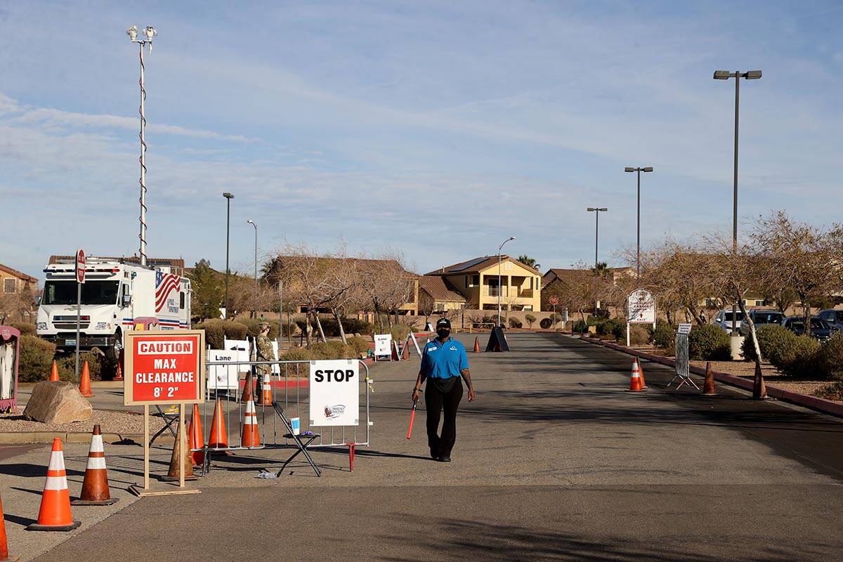 Workers and National Guard members wait for cars at the drive-thru COVID-19 test site at Fiesta ...
