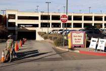 Workers and National Guard members wait for cars at the drive-thru COVID-19 test site at Fiesta ...