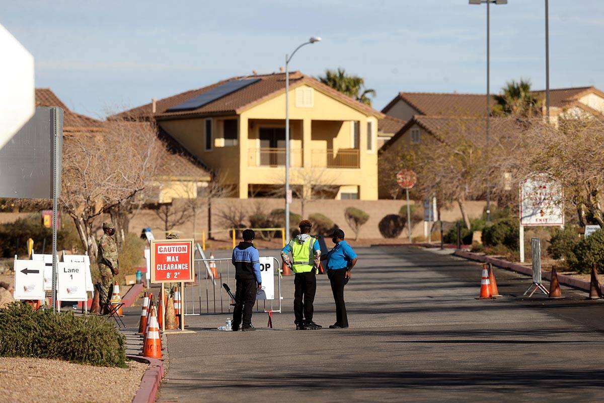 Workers and National Guard members wait for cars at the drive-thru COVID-19 test site at Fiesta ...