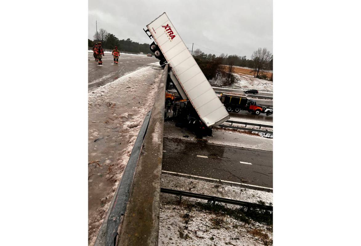 In this photo provided by the Durham Police Department, a truck hangs from the highway N.C. 147 ...