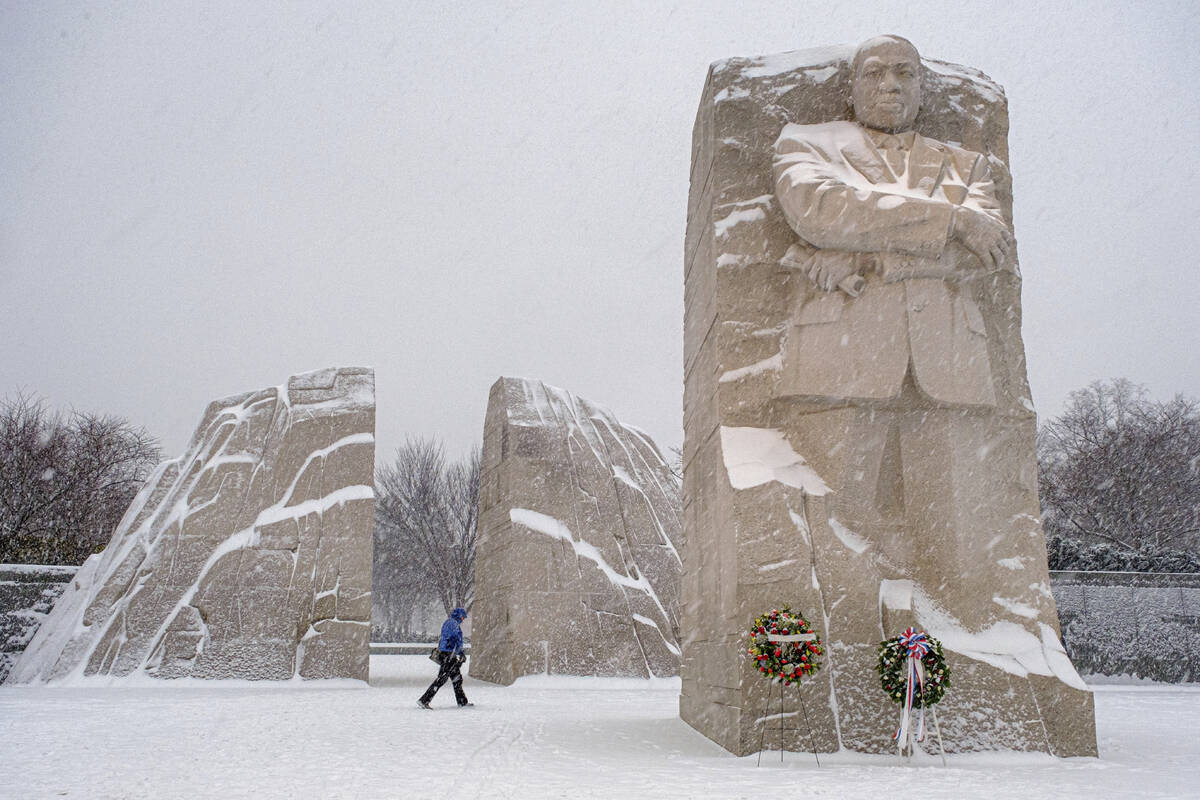 A visitor walks through the Martin Luther King, Jr. Memorial as a winter storm blows through th ...