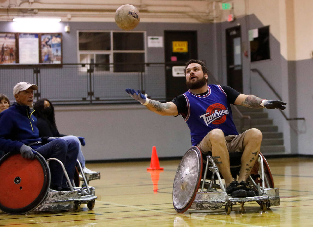 Peter Vinnitsky, High Rollers coach, right, tries to get a ball during a wheelchair rugby demon ...