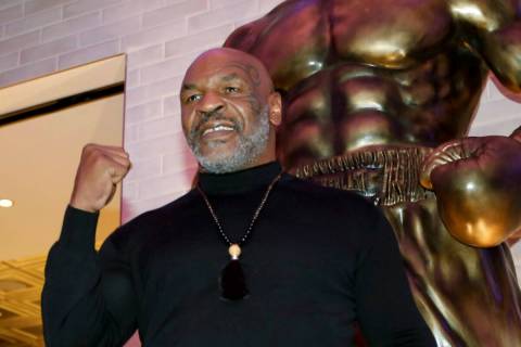 Former boxer Mike Tyson poses for photos in front of newly unveiled Tyson's stature at Mulberry ...
