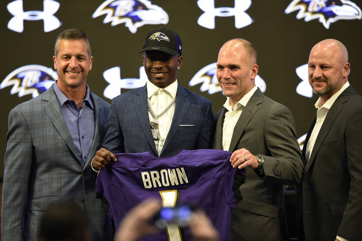 Baltimore Ravens 1st-round draft pick Marquise Brown, center, stands with head coach John Harba ...
