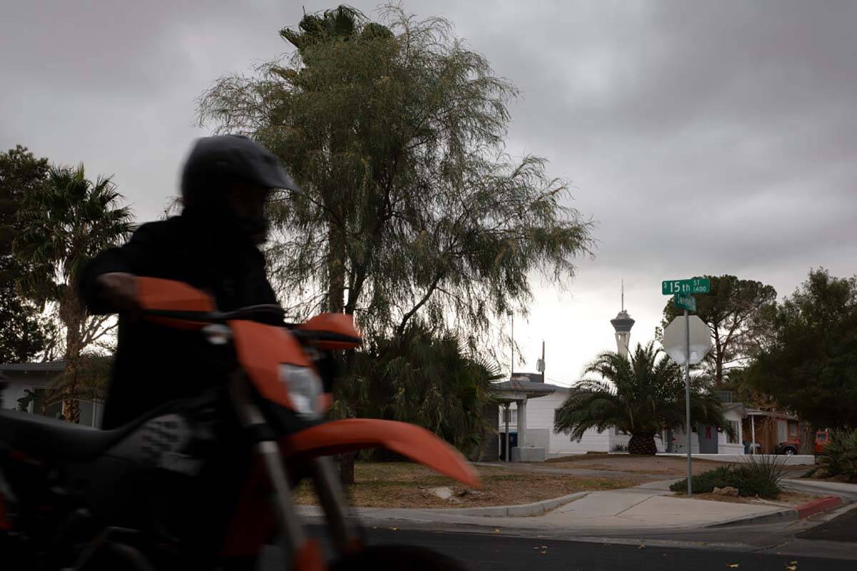 A motorcyclist walks his bike down South 15th Street as stormy skies linger above on Tuesday, D ...