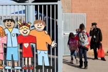 Monica Porter prepares a mask for first grader Dymond Chandler at Williams Elementary in Las Ve ...