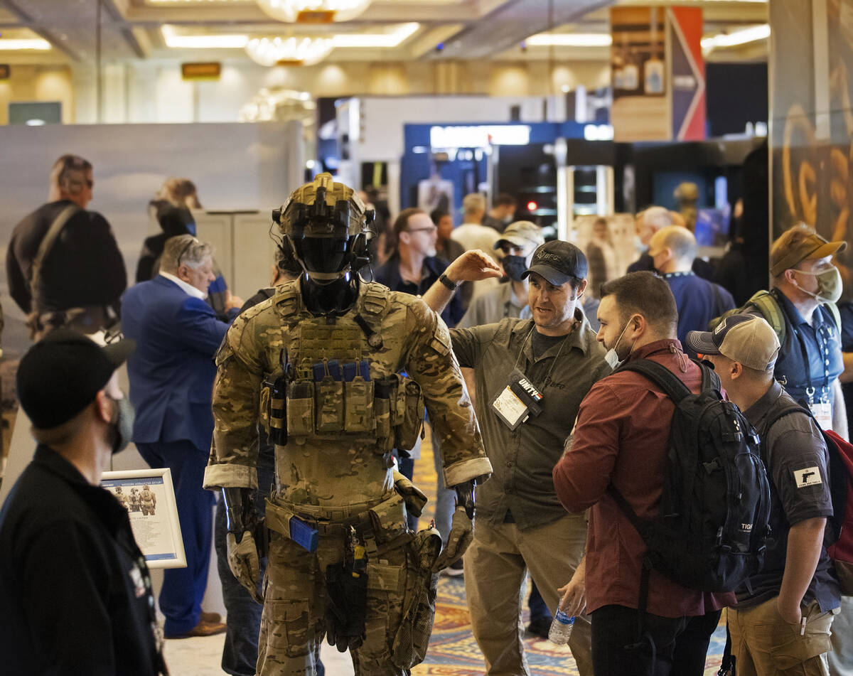 Chris Sizelove, middle, with Blue Force Gear Inc., speaks with attendees during the SHOT Show s ...