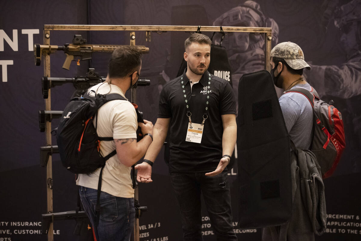 Tyson Jex, middle, with AEGIX Global, speaks with attendees during the SHOT Show shooting, hunt ...