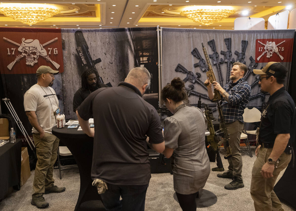 People look at guns at Sons of Liberty Gun Works during the SHOT Show shooting, hunting and out ...