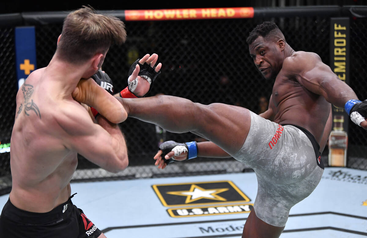Francis Ngannou of Cameroon kicks Stipe Miocic in their UFC heavyweight championship fight duri ...