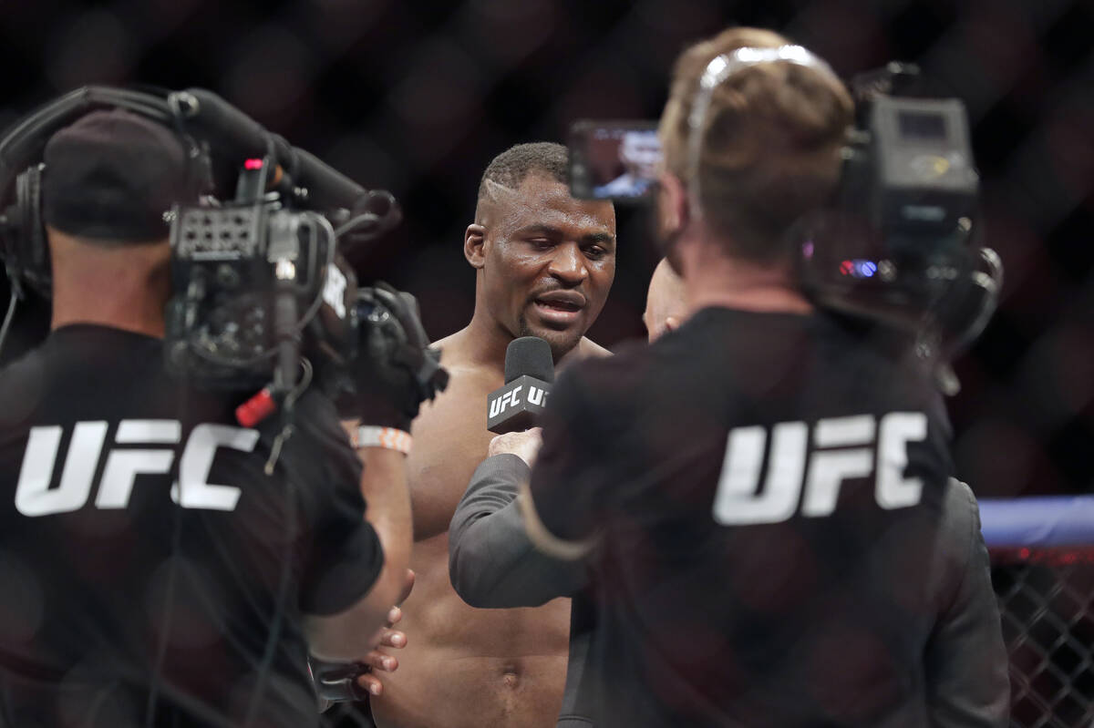 Francis Ngannou, center, is interviewed after winning a UFC 249 mixed martial arts bout against ...