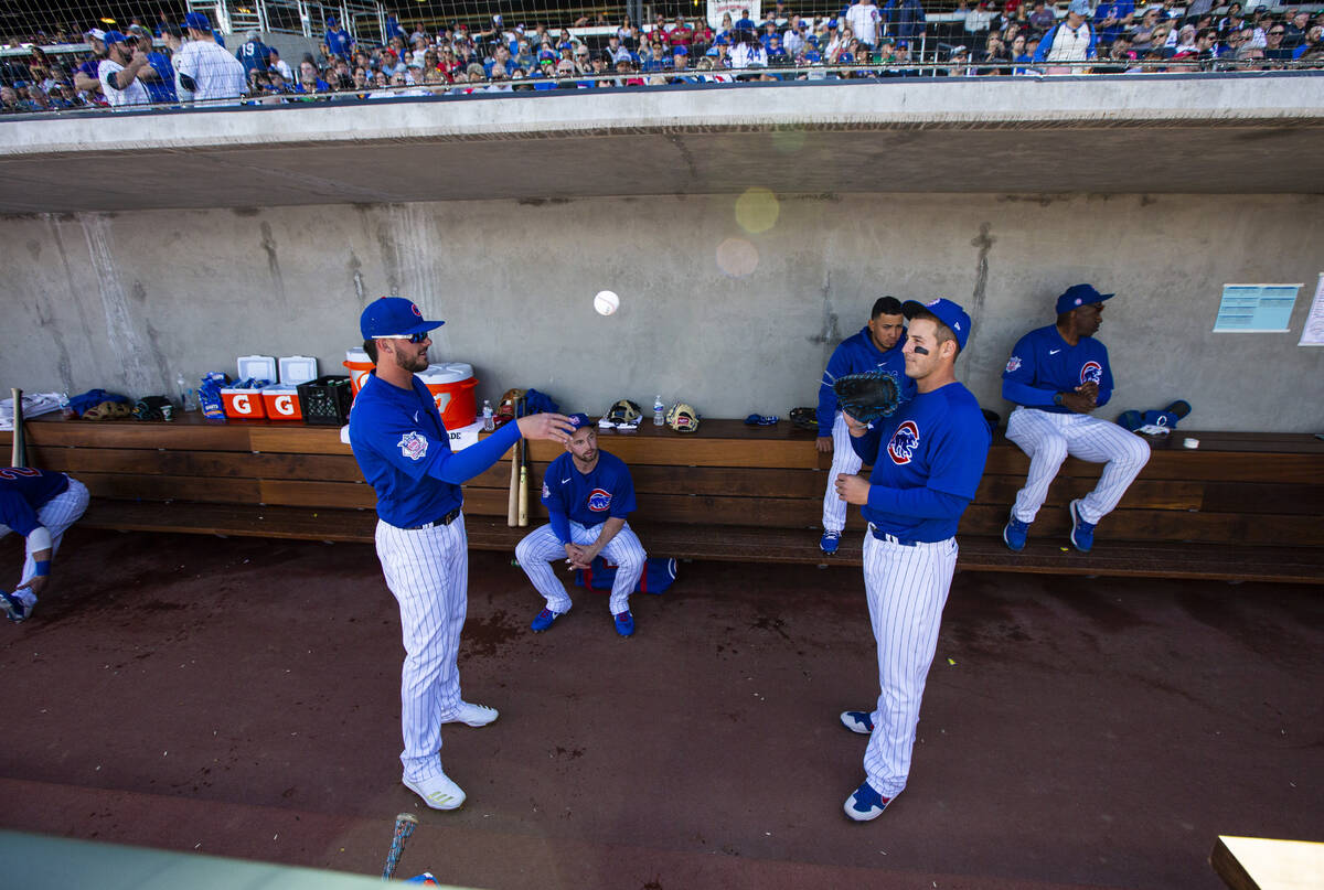 Chicago Cubs' Kris Bryant, left, and Anthony Rizzo, right, pass a baseball before the start of ...