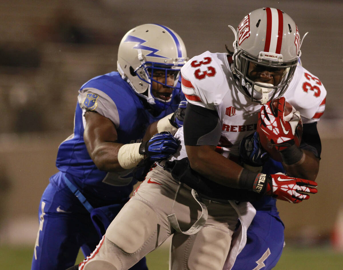 UNLV running back Shaquille Murray-Lawrence, front, is dragged down after a long gain by Air Fo ...